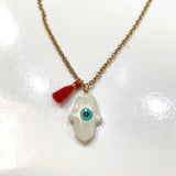 Pieza confeccionada a mano con "Charms" Mano de Fatima con un ojo turco integrado en nácar montada en una cadena de stainless steel. Excelente joyería que no se despinta y tiene un bello color perlado precioso.