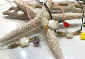 Collar confeccionado a mano con flor en nácar montada en hilo de nylon ajustable. Excelente joyería que no se despinta y tiene un bello estilo moderno y fino. 